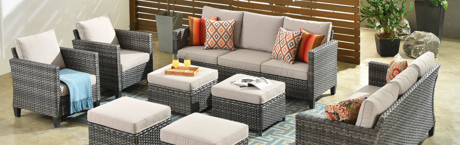 Gray wicker patio furniture set with beige cushions.